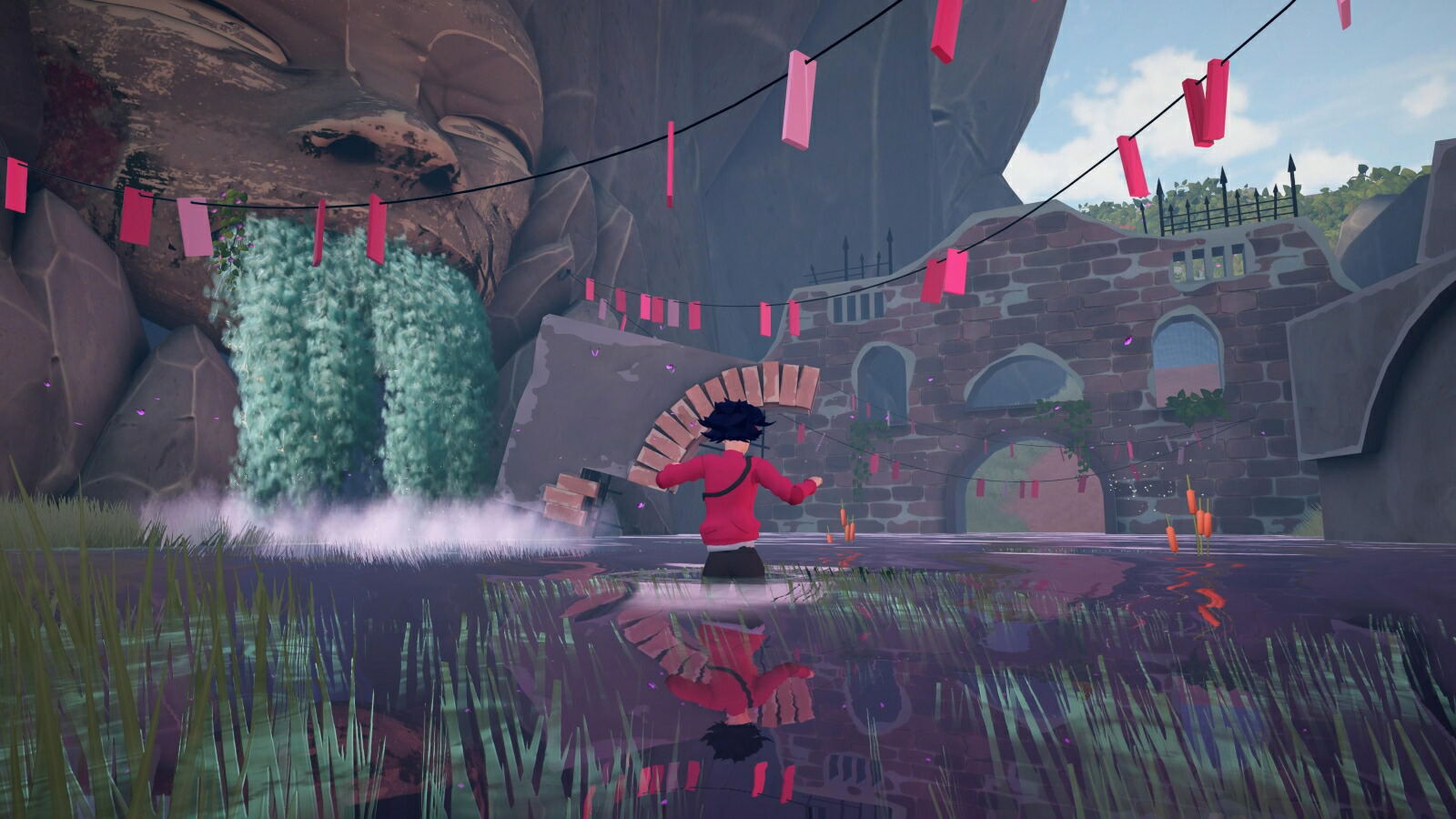 A stylized 3D-rendered scene showing a person in a red top and dark pants standing in shallow water, facing a stone structure with arches and pink hanging flags. The environment includes rocks, water, grass, and a partly visible sky.