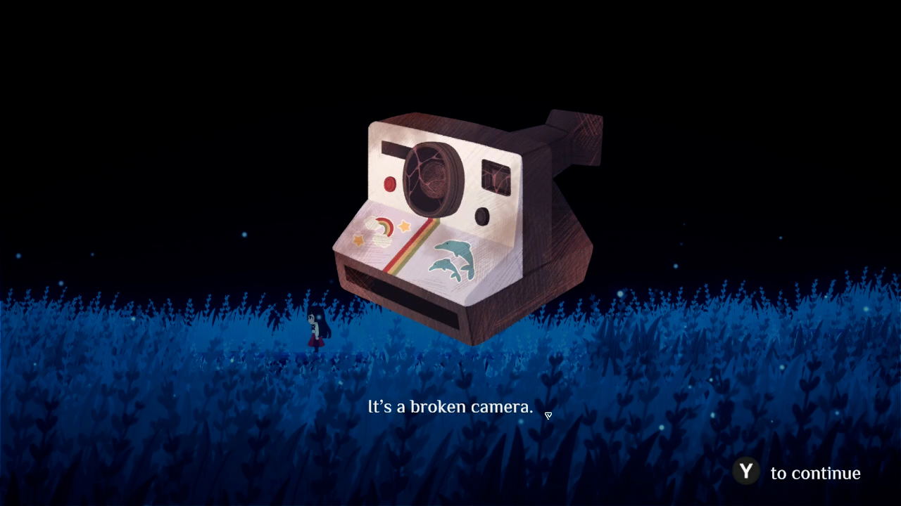 Broken camera in a grassy field with a dark sky