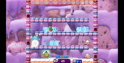 A screenshot from a colorful video game showing a character jumping on pink-and-white striped platforms in a whimsical candy-themed environment with pastel purple background elements.