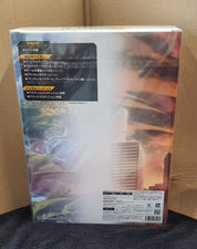 The back of a boxed collectible figure or model kit package, photographed standing upright against a cardboard box background. The package artwork shows a fantasy creature and a cityscape with dramatic orange and blue tones, plus large Japanese text panels and a barcode at the bottom.