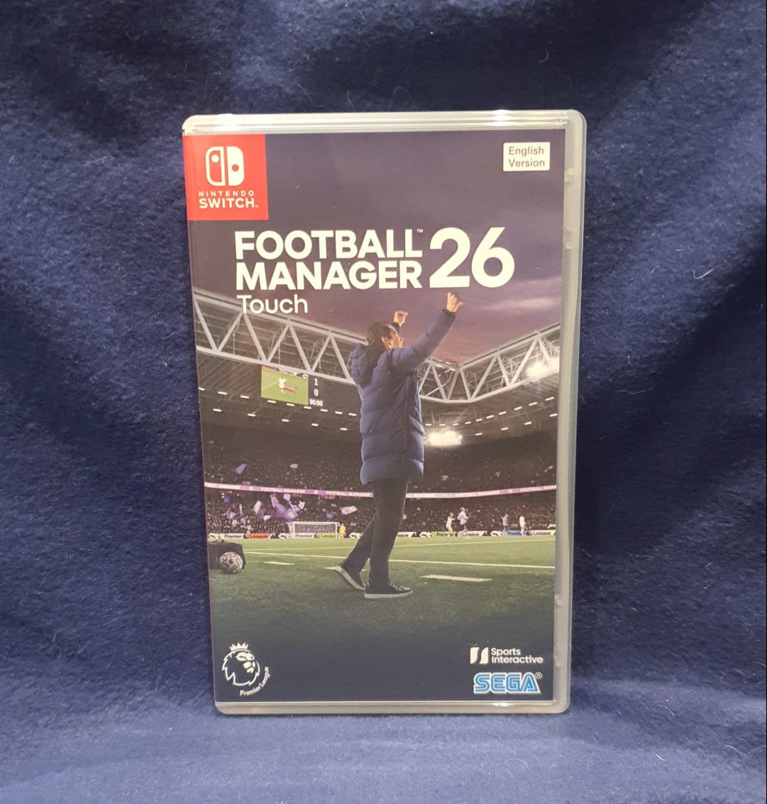 Packaging of 'Football Manager 26 Touch' for Nintendo Switch on a blue fabric background