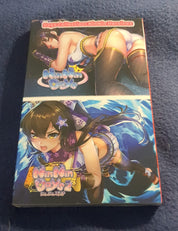 A boxed anime collectible or DVD set photographed on a dark blue textured fabric surface. The front cover shows two illustrated female anime characters, one in a white bikini on the upper half and one in a purple outfit with blue effects on the lower half.