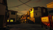 A dark, atmospheric street scene at dusk or dawn with narrow buildings, overhead wires, and warm yellow light glowing from windows. A red-and-white striped construction barrier with Japanese characters stands in the lower right foreground.