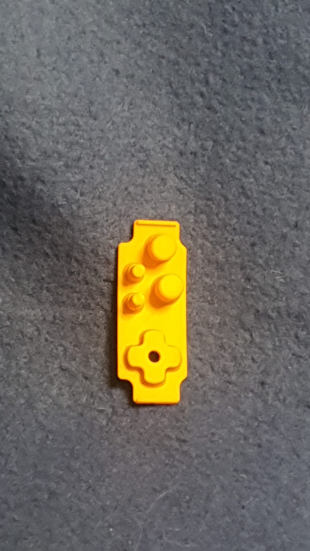 Yellow toy brick on a gray surface