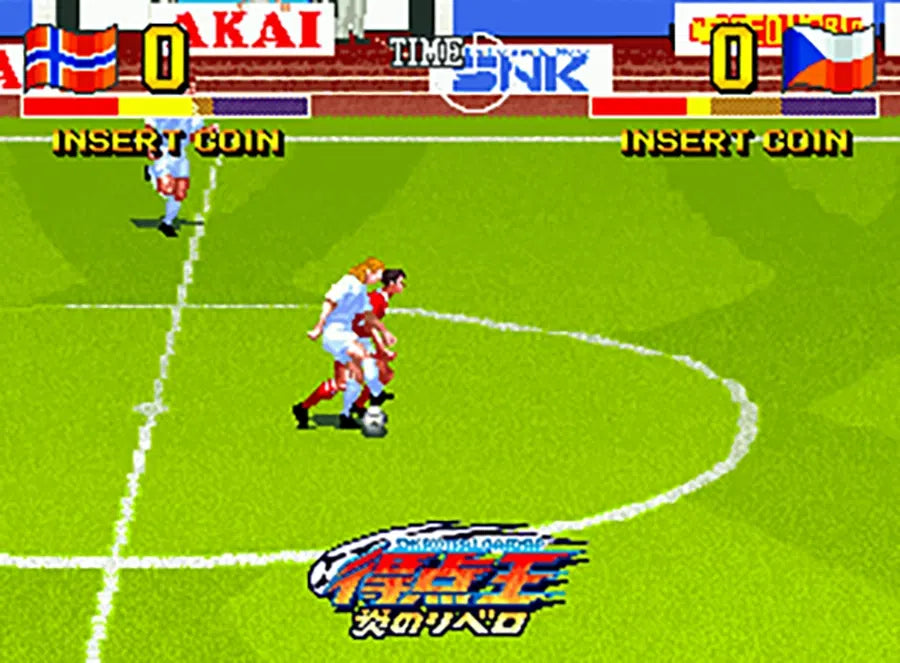 Soccer game in progress with two players on a virtual field, surrounded by colorful advertisements and branding.